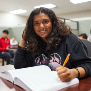 A high school student studying at a desk to raise her GPA.